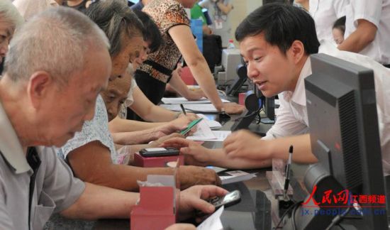 南昌市東湖區(qū)和市民政局工作人員向居家老人介紹專用手機(jī)如何使用。