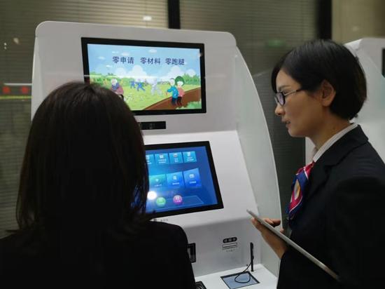 工作人員指導(dǎo)市民使用自助服務(wù)機(jī)。浙江省人社廳供圖