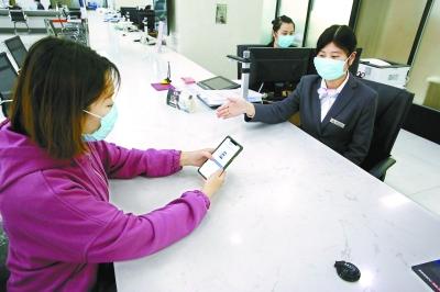  在東城區(qū)政務服務大廳，前來辦事的企業(yè)工作人員通過“北京通”授權電子證照應用